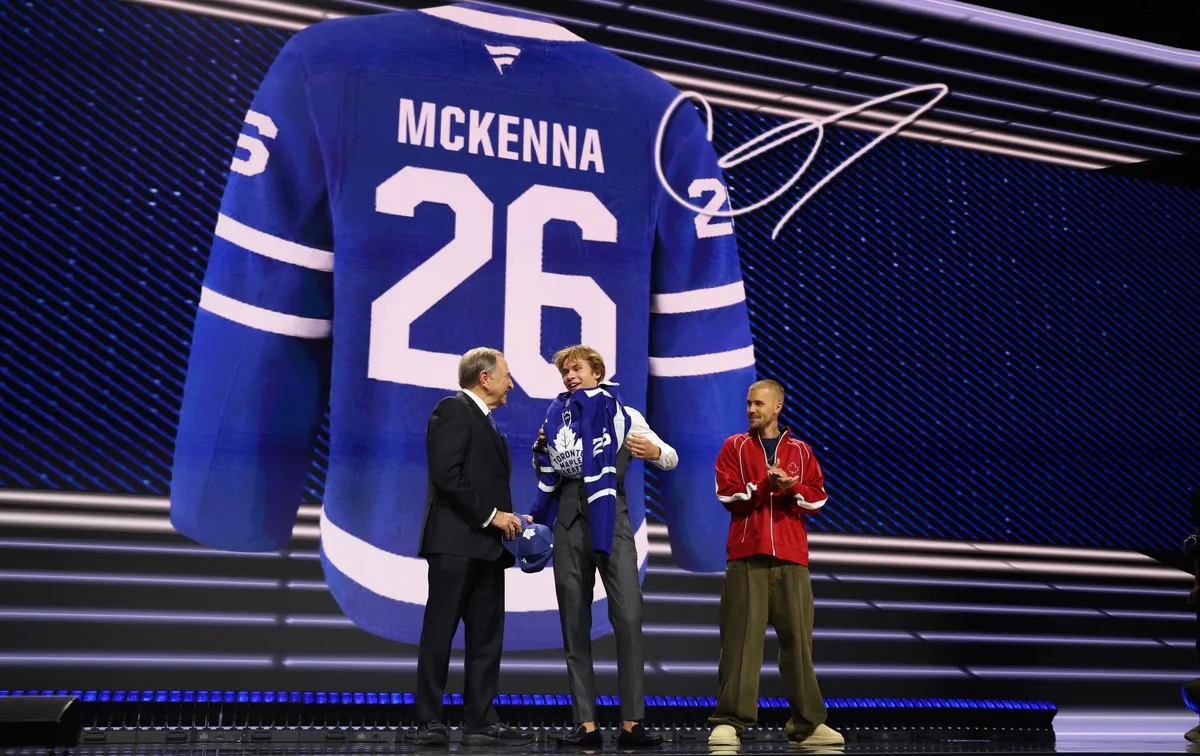 26 de junio de 2026; Búfalo, Nueva York, Estados Unidos; Gavin McKenna lleva un suéter junto al comisionado de la NHL Gary Bettman y el cantante Justin Bieber después de ser seleccionado con la primera selección en la primera ronda del Draft de la NHL 2026 por los Toronto Maple Leafs en el KeyBank Center. Crédito obligatorio: Timothy T. Ludwig-Imagn Images