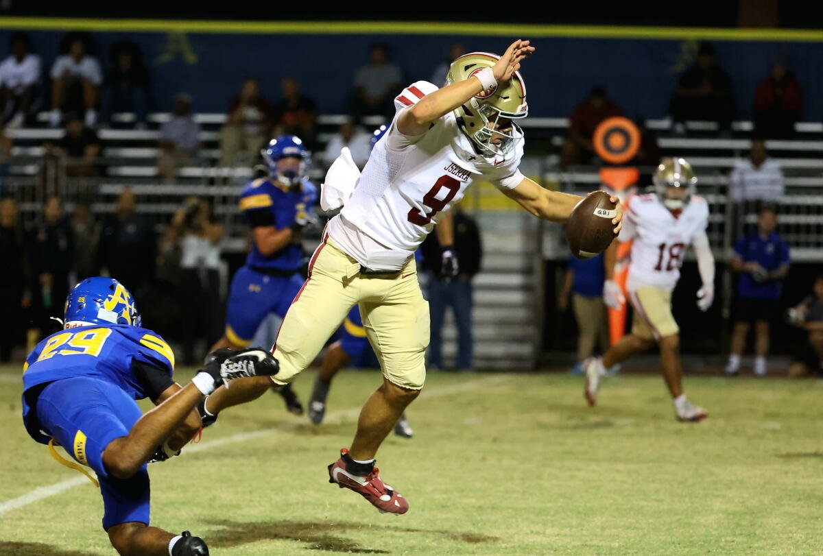 El mariscal de campo de JSerra High, Hayes Cloutier, salta mientras intenta evitar una entrada de un defensor de Bishop Amat.