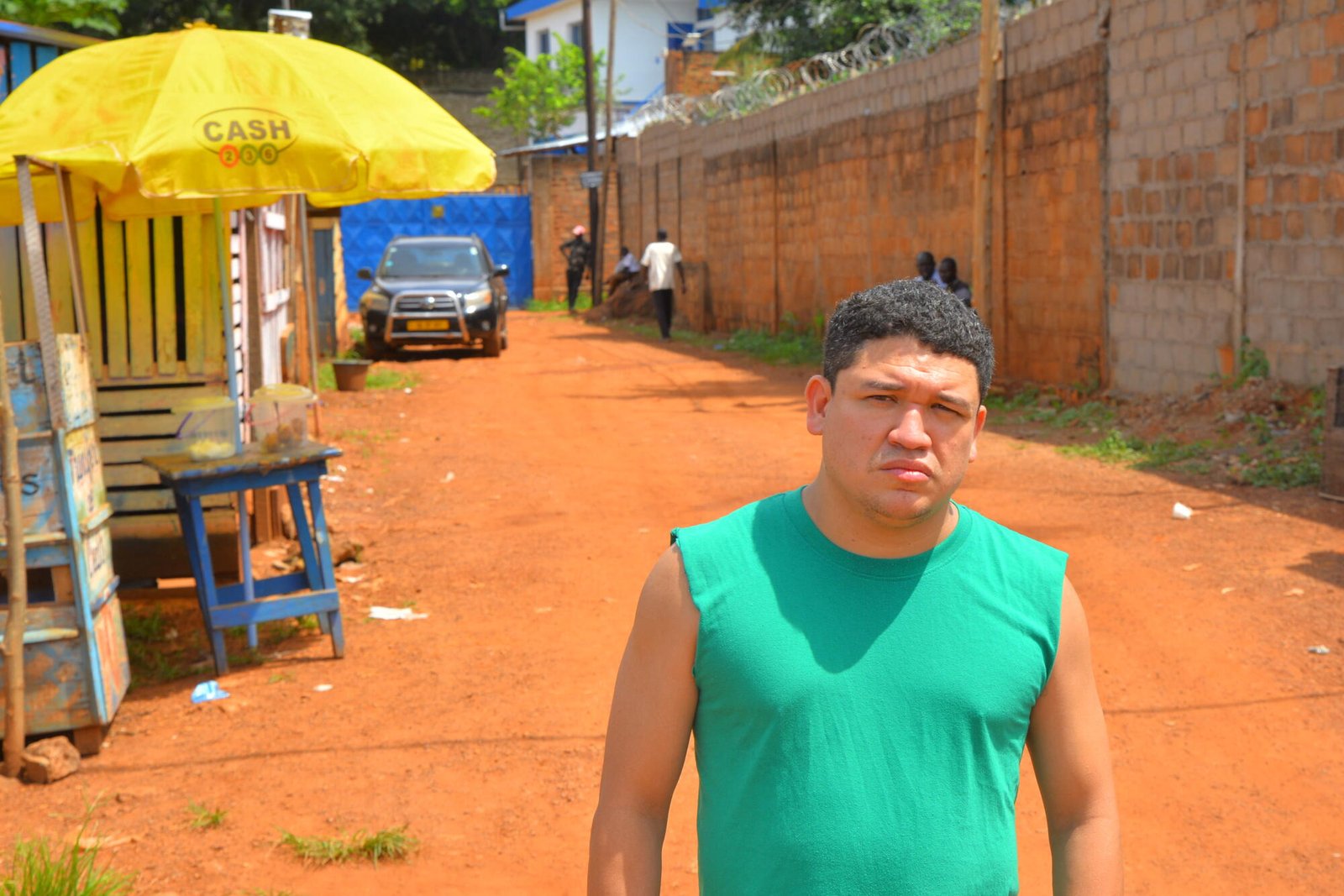 En el camino de tierra había un hombre que llevaba una camisa con las mangas cortadas.  