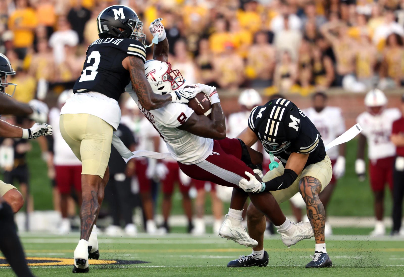 COLUMBIA, MISSOURI - 19 DE SEPTIEMBRE: El receptor abierto de los Troy Trojans, Tk Keyes # 8, es abordado por el cornerback de los Missouri Tigers, Seon Laulia # 2, y el safety Trajan Greco # 4 durante la primera mitad de un juego en Faurot Field en el Memorial Stadium el 19 de septiembre de 2016 en Missouri. (Foto de Jamie Squire/Getty Images)