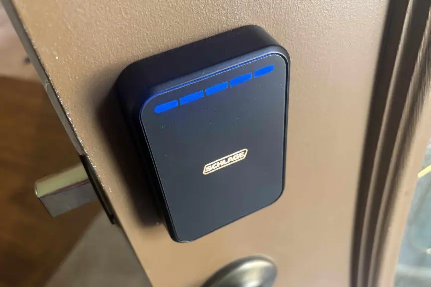 Una puerta marrón abierta tiene una cerradura Schrager negra.