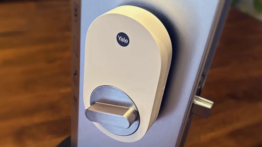 La cerradura inteligente de Yale se encuentra sobre una plataforma de prueba de metal sobre una mesa de madera.