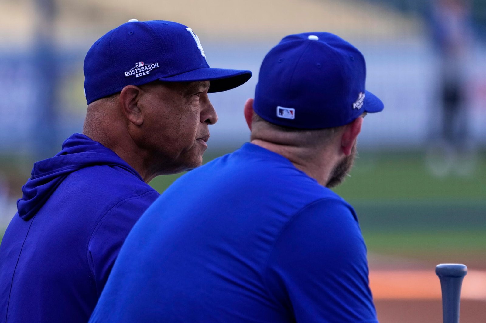 El manager de los Dodgers, Dave Roberts, izquierda, habla con el tercera base Max Muncie durante la práctica del jueves.