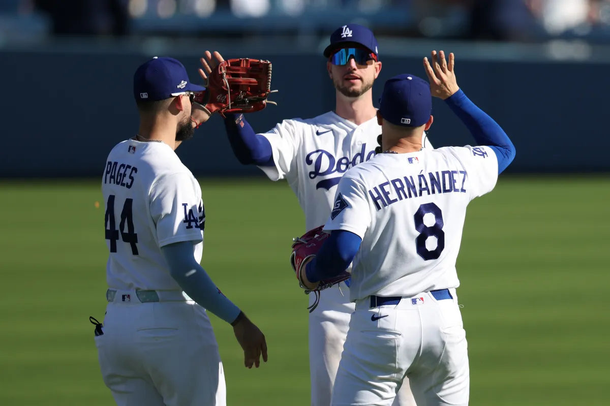 3 de octubre de 2026; Los Ángeles, California, Estados Unidos; Desde la izquierda, el jardinero de los Dodgers de Los Ángeles Andy Pages (44), el jardinero Kyle Tucker (23) y el primera base Enrique Hernández (8) reaccionan después de derrotar a los Bravos de Atlanta en el primer juego de la NLDS de los playoffs de la MLB de 2026 en el Uniqlo Field del Dodger Stadium. Crédito obligatorio: Imagen de Kiyoshi Mio-Imagon