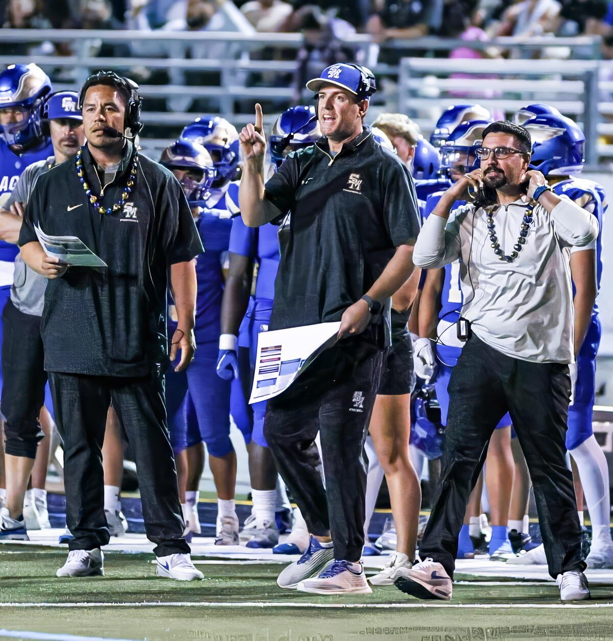 El entrenador de Santa Margarita, Carson Palmer, centro, junto con el coordinador ofensivo Lenny Vandermade, izquierda.