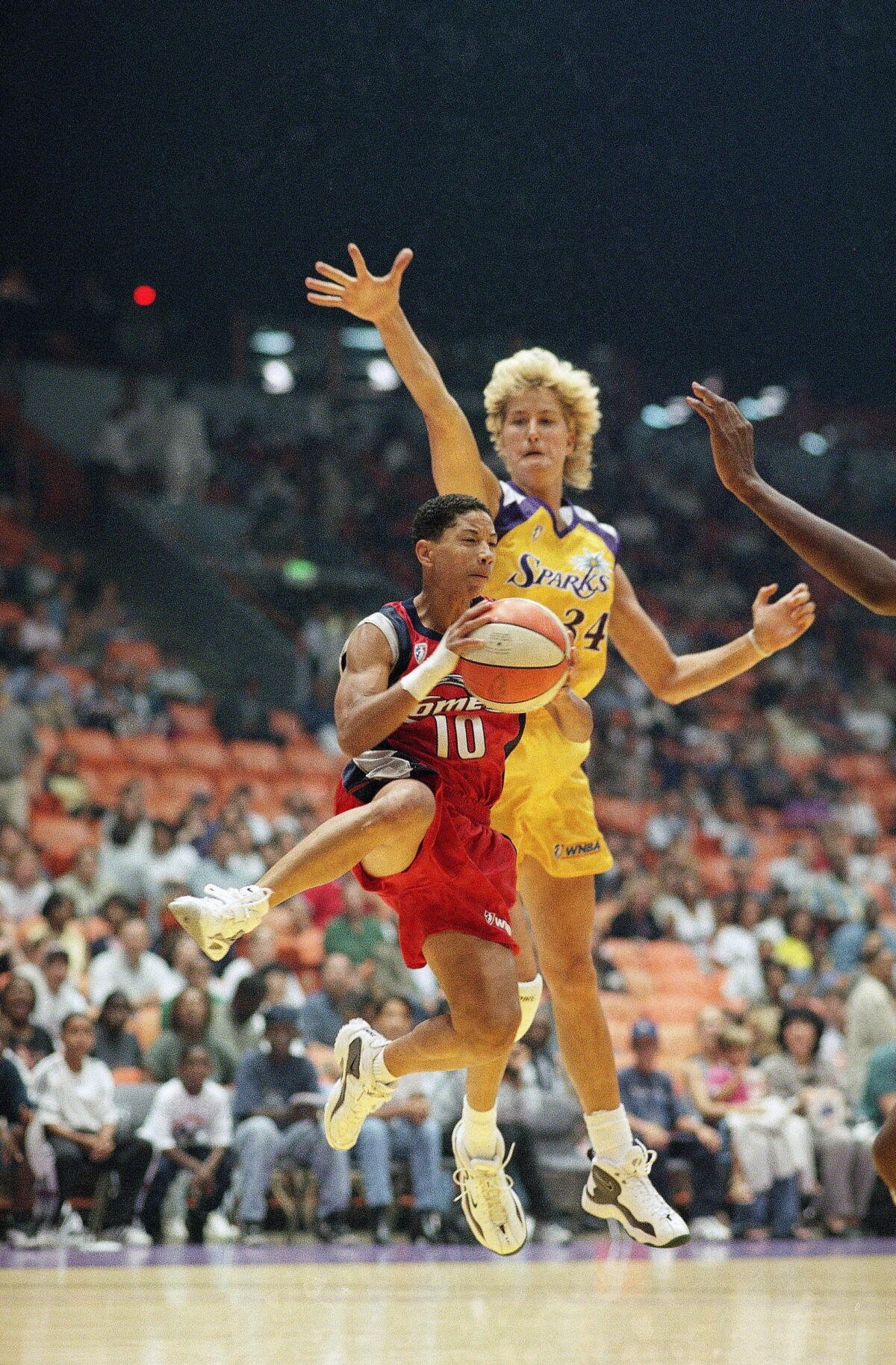 Heidi Berg, derecha, se levanta para bloquear al guardia de los Houston Comets, Kim Perot, durante un partido el 16 de julio de 1997.