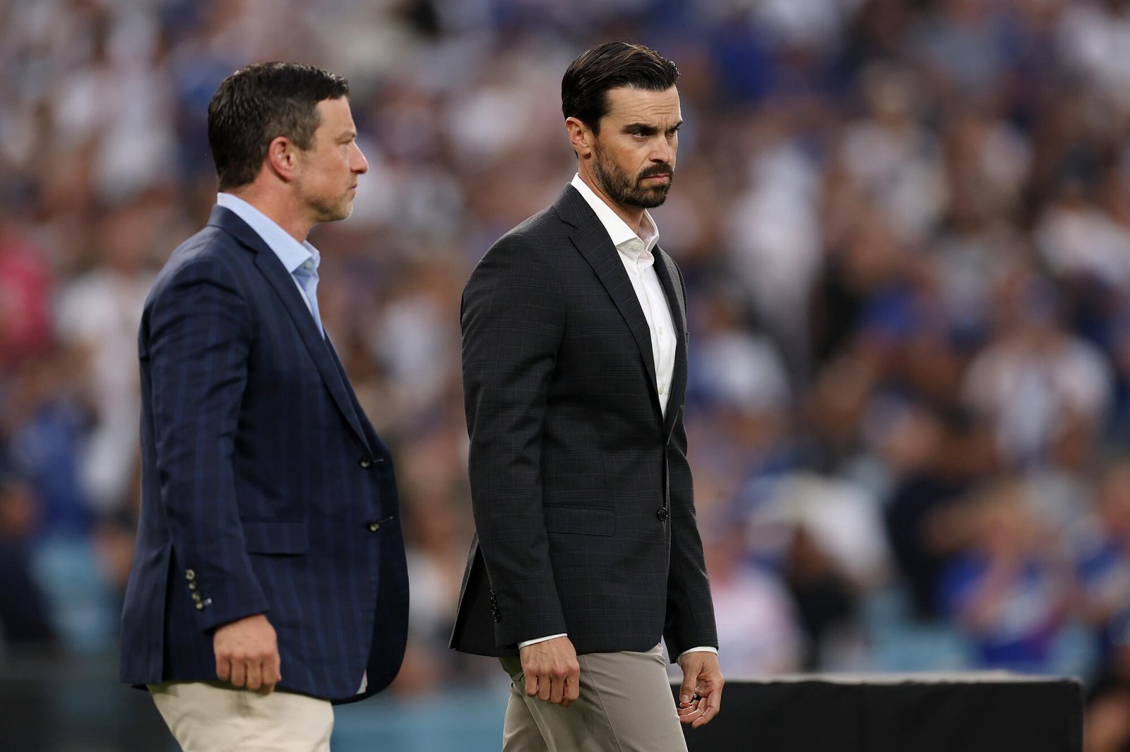 El presidente de operaciones de béisbol de los Dodgers, Andrew Friedman (izquierda), y el gerente general Brandon Gomes observan antes de un partido.
