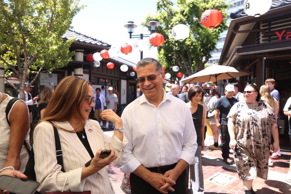 Segundo. Xavier Becerra, centro, candidato a gobernador de California, camina con Helen Ota.