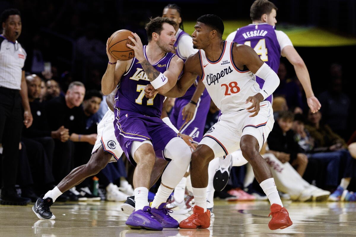 El delantero de los Clippers, Rui Hachimura, derecha, golpea al base de los Lakers, Luka Doncic, durante la primera mitad del viernes.