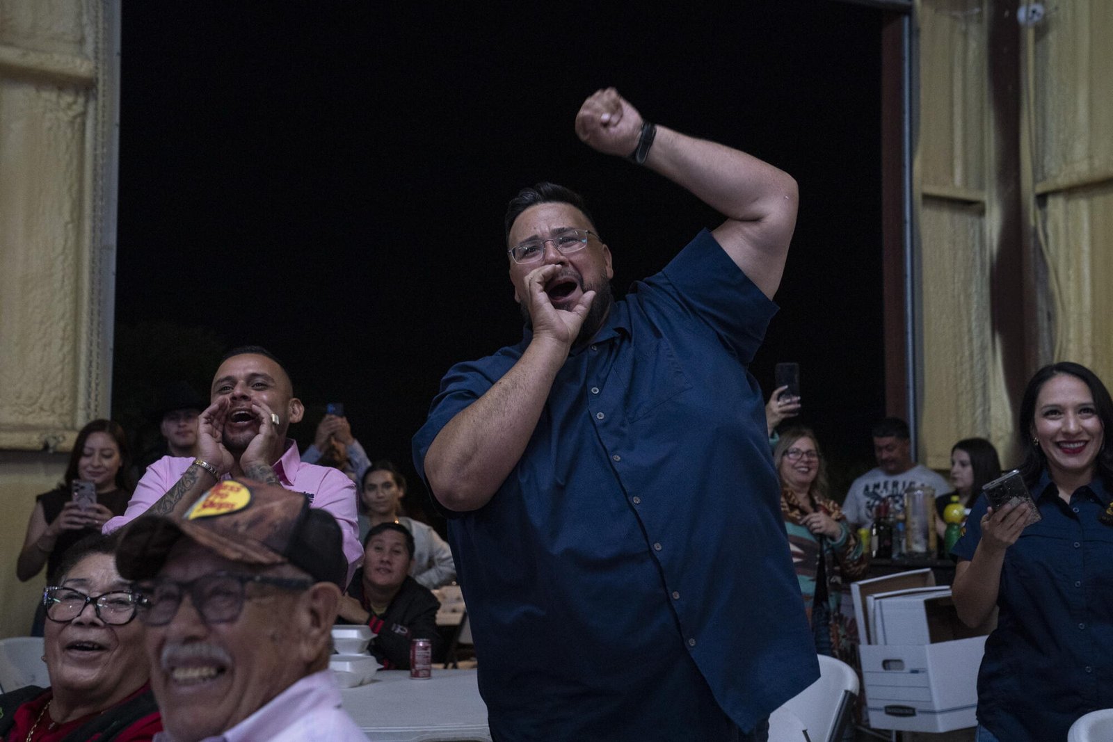 La gente vitoreó cuando un hombre que vestía una camisa oscura de manga corta levantó el puño mientras hablaba en la manifestación.