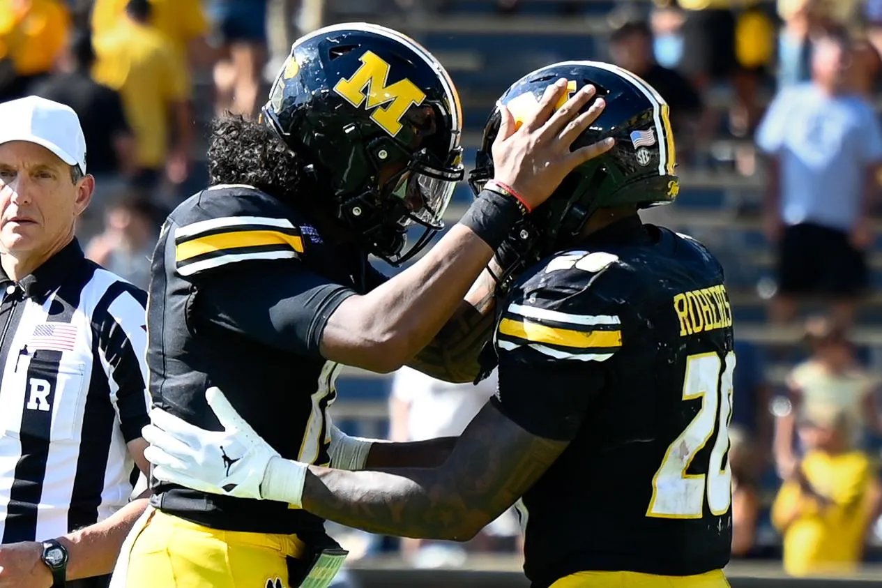 Austin Simmons (13) celebra con Jamal Roberts (20) después de arrodillarse por última vez y asegurar la victoria de los Tigres sobre Texas A&M el sábado 10 de octubre en el Memorial Stadium de Columbia.