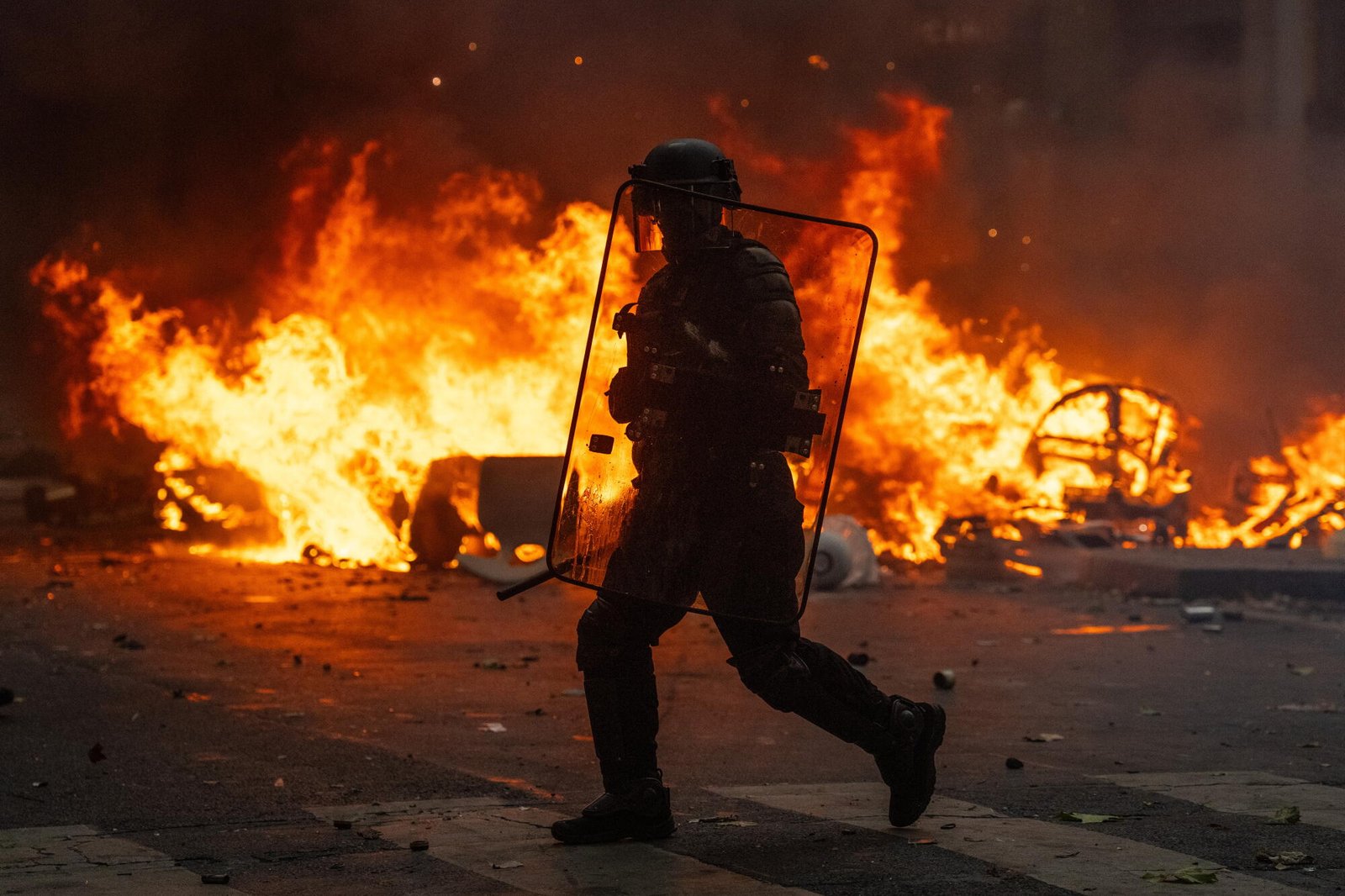 Oficiales de policía corriendo frente al fuego. 
