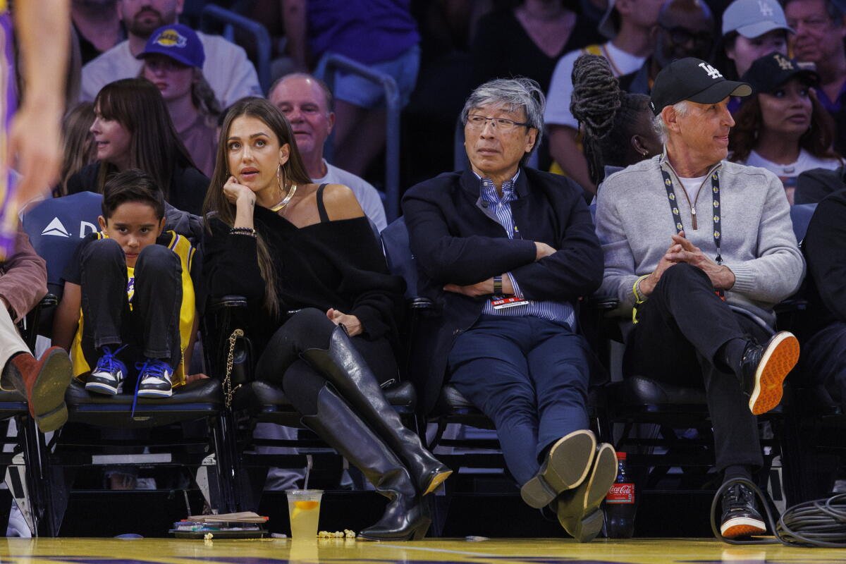 Patrick Soon-Shiong, propietario minoritario de los Lakers, se sienta junto a la actriz Jessica Alba durante un partido de los Lakers.
