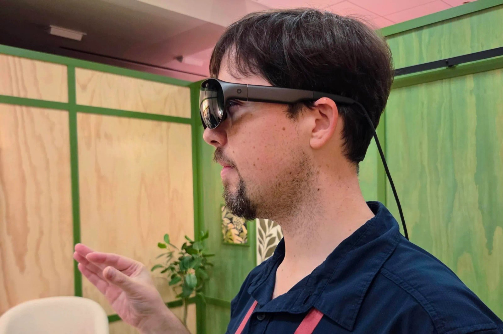 Sean Hollister usa un casco de realidad virtual Meta, con un cable colgando debajo de la parte posterior de su cabeza.