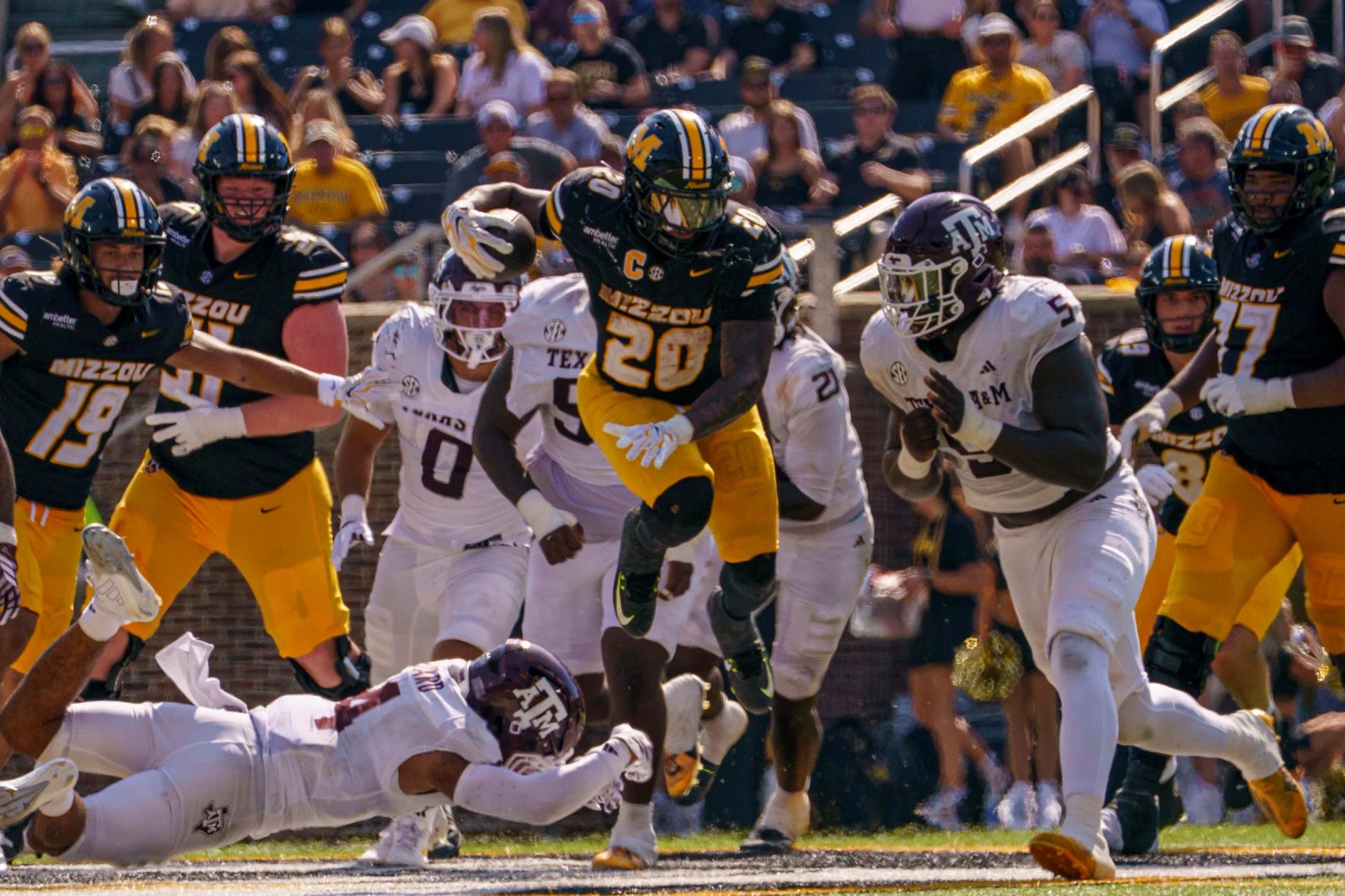 El safety de Texas A&M, Tawfiq Byard (4), es interceptado por el corredor de Missouri Jamal Roberts (20) durante el tercer cuarto de un juego el sábado 10 de octubre en el Memorial Stadium de Columbia.