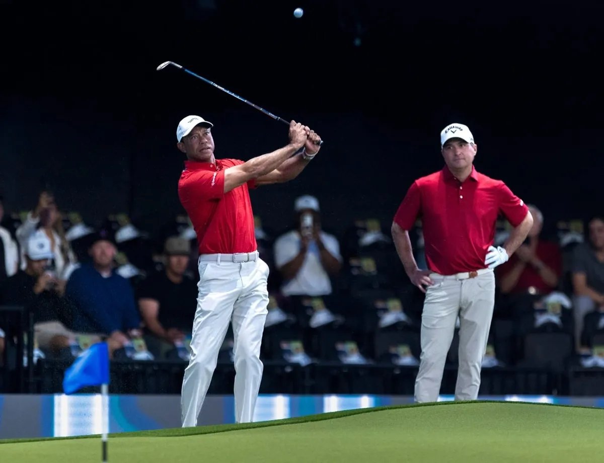 Tiger Woods golpea la pelota junto a Kevin Kisner de Jupiter Links antes de un partido de TGL contra el New York Golf Club el 13 de enero de 2026 en Palm Beach Gardens, Florida.