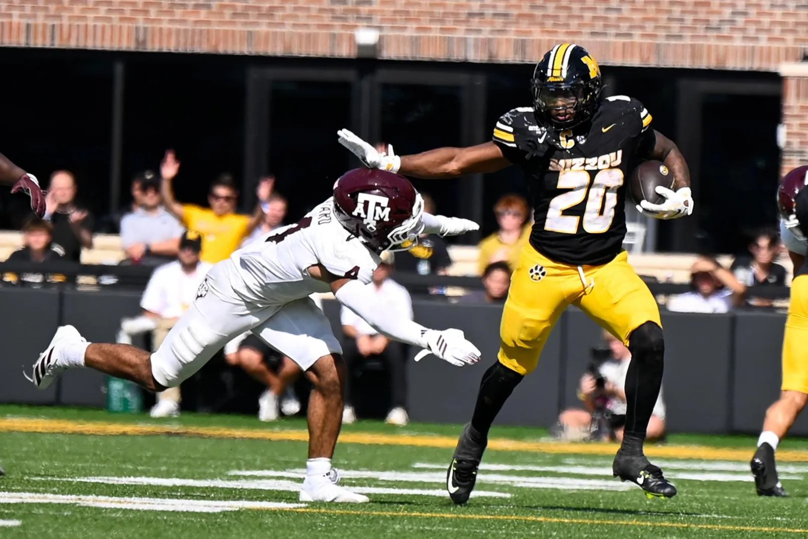 El ala cerrada Jamaal Roberts (20) ataca al defensor de Texas A&M, Toufiq Byrd (4), el sábado 10 de octubre en el Memorial Stadium de Columbia, MO. La carrera de Roberts fue anulada debido a una falta personal.