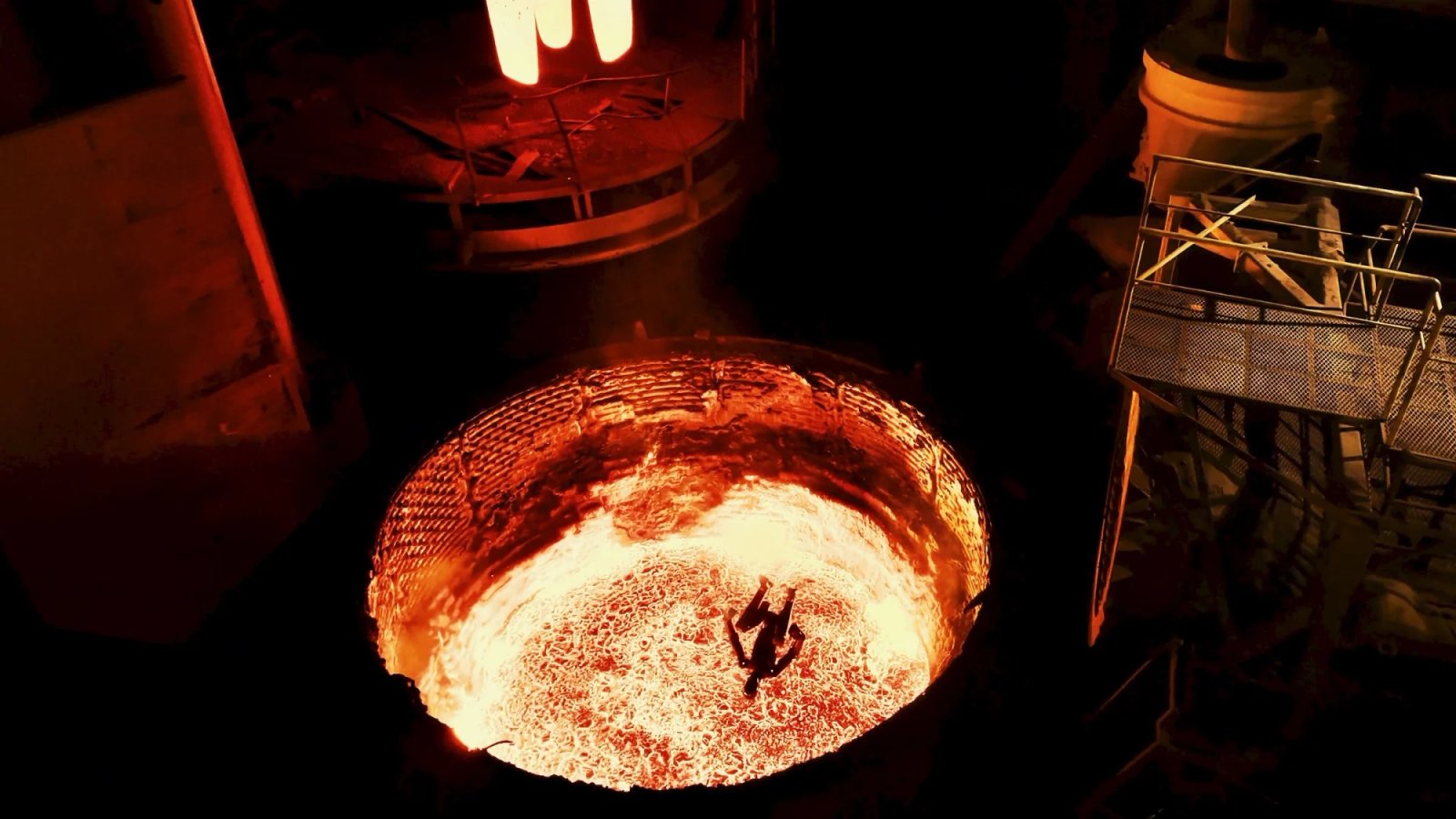 Un robot humanoide dispara proyectiles hacia un horno de acero fundido