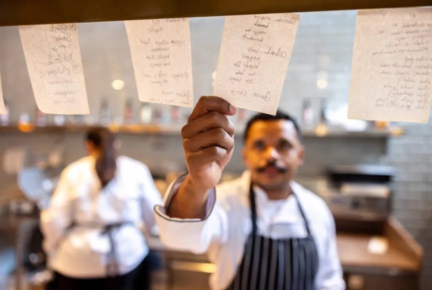 Un trabajador de un restaurante lucha por conseguir un cupón para pedir comida.